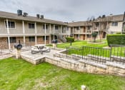 Thumbnail 2 of 36 - the backyard with a fire pit at Juniper Springs Apartments, Austin, TX