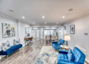 Thumbnail 35 of 36 - a living room with blue couches and a dining room with a table and chairs