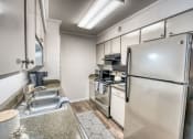 Thumbnail 14 of 36 - the kitchen has stainless steel appliances and white cabinets at Juniper Springs Apartments, Austin, TX