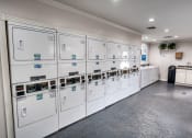 Thumbnail 17 of 36 - a utility room with many white utility machines in it at Juniper Springs Apartments, Austin, TX