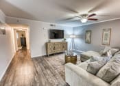 Thumbnail 12 of 36 - a living room with a couch and a ceiling fan at Juniper Springs Apartments, Austin, TX