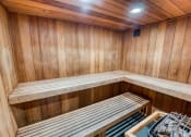 Thumbnail 27 of 36 - a sauna with wooden walls and wooden benches at Juniper Springs Apartments, Austin, TX