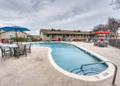 Thumbnail 6 of 36 - our apartments have a resort style pool with chairs and umbrellas at Juniper Springs Apartments, Austin, TX