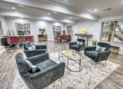 Thumbnail 22 of 37 - Clubhouse seating area with gray armchairs and coffee table at Le Montreaux Apartments, Texas, 78759