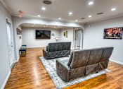 Thumbnail 18 of 37 - Basement recreation room with leather recliners at Le Montreaux Apartments, Texas, 78759
