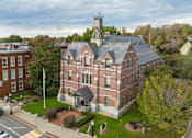Thumbnail 14 of 17 - A large red brick building with a tower on top.