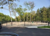 Thumbnail 17 of 17 - A black car is parked in a parking lot with a playground in the background.