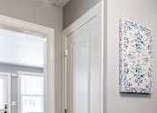 Thumbnail 6 of 17 - A white door is open to a room with a blue chair and a blue and white picture on the wall.