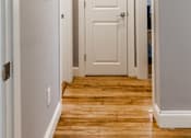 Thumbnail 11 of 17 - A white door is in the middle of a hallway.