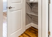 Thumbnail 13 of 17 - A white door is open to a pantry with shelves.