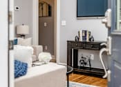 Thumbnail 7 of 17 - A bedroom with a bed, a dresser, a TV, and a bicycle on the wall.