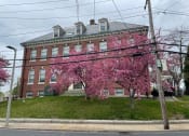 Thumbnail 2 of 2 - Historical school house building with colorful landscaping