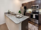 Thumbnail 1 of 44 - a kitchen with granite countertops and stainless steel appliances at Ardmore at the Trail, Indian Trail, North Carolina