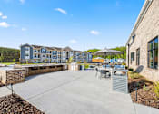 Thumbnail 6 of 35 - Outdoor patio with grills and dining furniture at Ardmore at Prosperity Apartments, Knoxville, TN