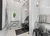 Thumbnail 8 of 30 - A bathroom with a white tiled wall and a black and white photo on the wall.