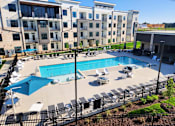 Thumbnail 5 of 5 - A large swimming pool surrounded by a black fence and lounge chairs.