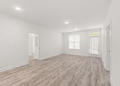 Thumbnail 29 of 30 - A room with wooden flooring and white walls.