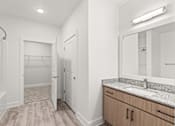 Thumbnail 26 of 30 - A bathroom with a sink, mirror, and wooden floors.
