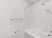 Thumbnail 20 of 30 - A white bathroom with a shower and a bathtub.