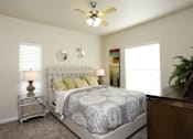 Thumbnail 1 of 8 - a bedroom with a bed and a ceiling fan