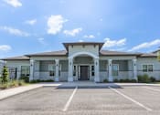 Thumbnail 1 of 3 - A building with a parking lot in front of it.