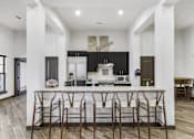 Thumbnail 7 of 8 - a kitchen with an island with bar stools