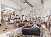 Thumbnail 3 of 6 - a living room with a leather ottoman and a leather couch