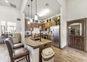 Thumbnail 4 of 6 - a kitchen and living room with a table and chairs