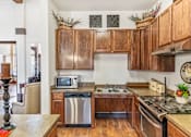 Thumbnail 1 of 6 - a kitchen with wooden cabinets and stainless steel appliances