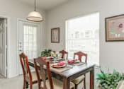 Thumbnail 8 of 12 - A dining room with a table set for a meal.