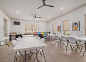 Thumbnail 9 of 16 - A room with a white table and chairs is shown.