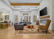 Thumbnail 6 of 16 - A living room with a grey couch and a wooden coffee table.
