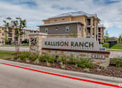 Thumbnail 11 of 16 - A sign for Kallison Ranch Apartments is in front of a building.