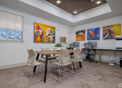 Thumbnail 12 of 16 - A room with a table, chairs and artwork on the wall.