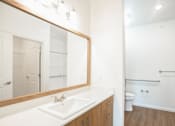 Thumbnail 5 of 9 - A bathroom with a white sink and a mirror.