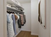 Thumbnail 19 of 26 - a walk in closet filled with clothes and a painting on the wall