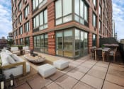 Thumbnail 10 of 26 - a large patio with furniture and a building in the background