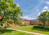 Thumbnail 6 of 39 - A large red brick building with a green lawn in front.