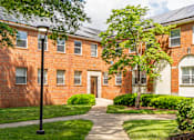 Thumbnail 7 of 39 - A red brick building with a tree in front.