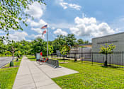 Thumbnail 38 of 39 - A flag is flying in front of a building with a black fence.