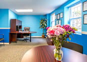 Thumbnail 3 of 39 - A conference room with a table, chairs, and a vase of flowers.