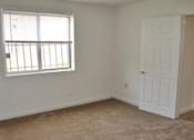 Thumbnail 33 of 39 - A room with a white door and a window with blinds.