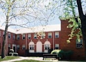 Thumbnail 12 of 39 - A red brick building with white trim and a white door.