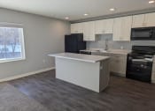 Thumbnail 2 of 115 - a kitchen with an island and a stove and a window