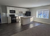 Thumbnail 3 of 115 - an empty kitchen with white cabinets and black appliances