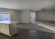 Thumbnail 4 of 115 - a kitchen and living room with a door to a patio