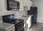 Thumbnail 1 of 115 - a kitchen with black appliances and white cabinets