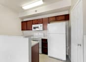Thumbnail 87 of 137 - a kitchen with white appliances and wooden cabinets