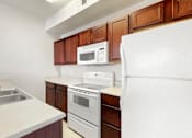 Thumbnail 89 of 137 - a kitchen with white appliances and wooden cabinets