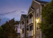 Thumbnail 36 of 137 - a row of houses at night with trees and a blue sky